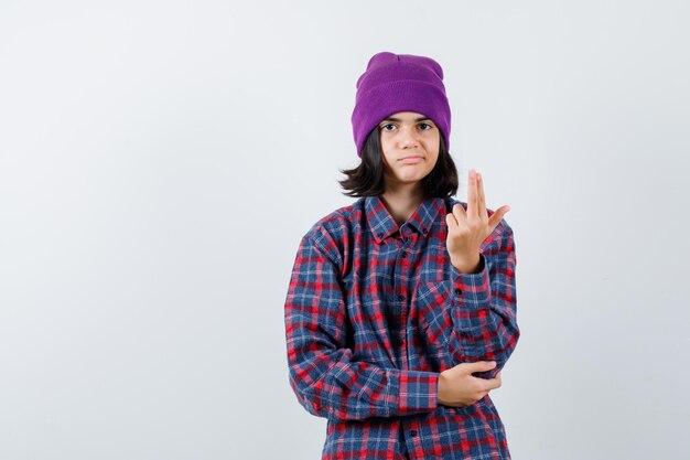 Tiener vrouw in geruit hemd en muts gebaren geïsoleerd