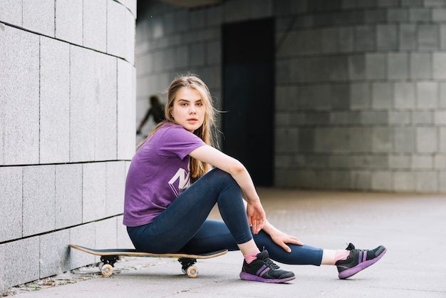 Gratis foto tiener zittend op skateboard