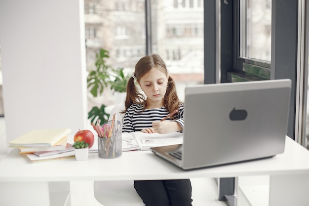 Tienermeisje dat laptop bekijkt. Chiln in quarantaine-isolatieperiode tijdens pandemie. Thuisonderwijs. Social distancing. Online schooltest.