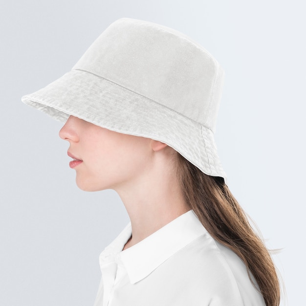 Tienermeisje in beige bucket hat voor street fashion shoot