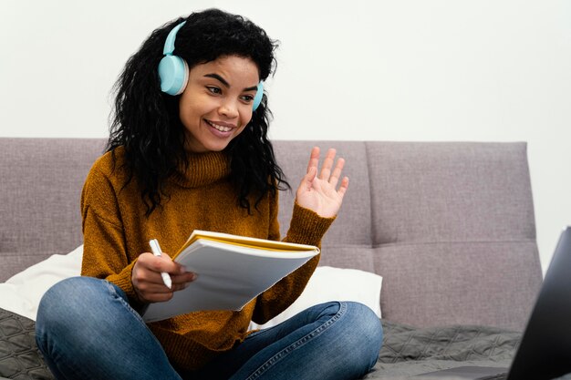 Tienermeisje met behulp van laptop en koptelefoon voor online school