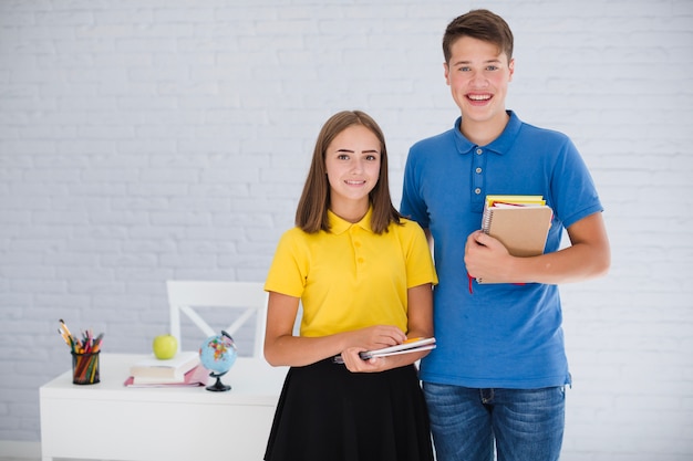 Tieners met notitieboekjes in de klas