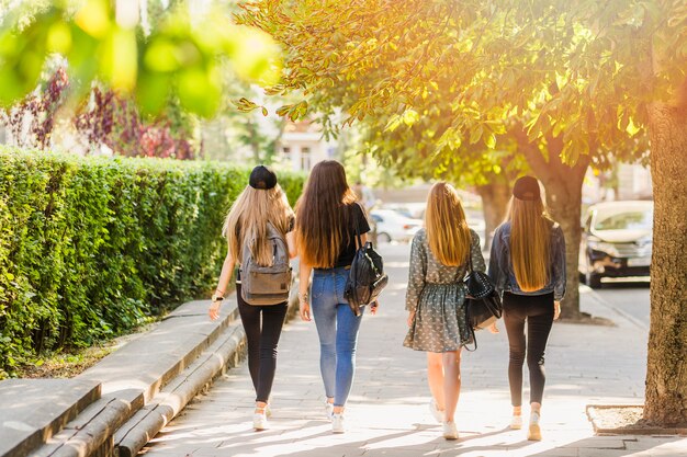 Tieners met rugzakken lopen op straat