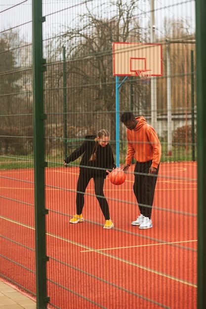 Tieners spelen basketbal buiten