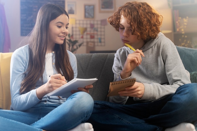 Tieners thuis spelen samen een spel op notebooks