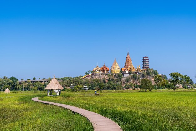 Tiger Cave Temple Wat Tham Suea in Kanchanaburi Thailand met groen rijstveld in zonnige dag