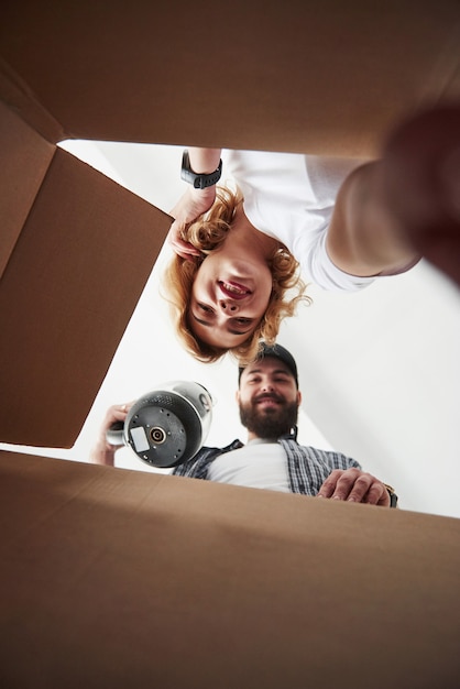 Tijd voor uitpakken. Gelukkig paar samen in hun nieuwe huis. Conceptie van verhuizen