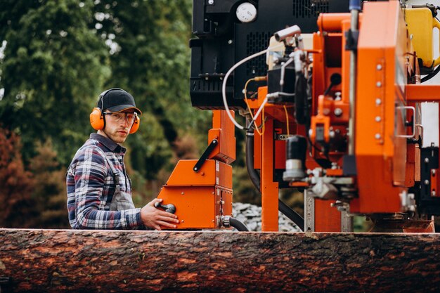 Timmerman die aan een zagerij aan een houten vervaardiging werkt