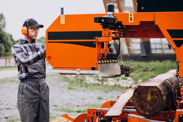 Timmerman die aan een zagerij aan een houten vervaardiging werkt