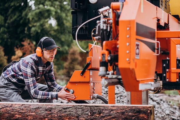 Timmerman die aan een zagerij aan een houten vervaardiging werkt