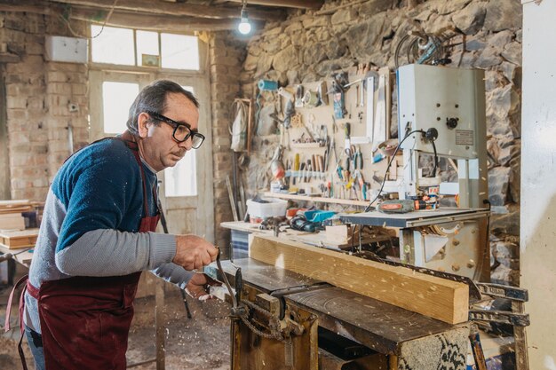 Timmerman die hout gebruikt om sculpturen te maken in het atelier
