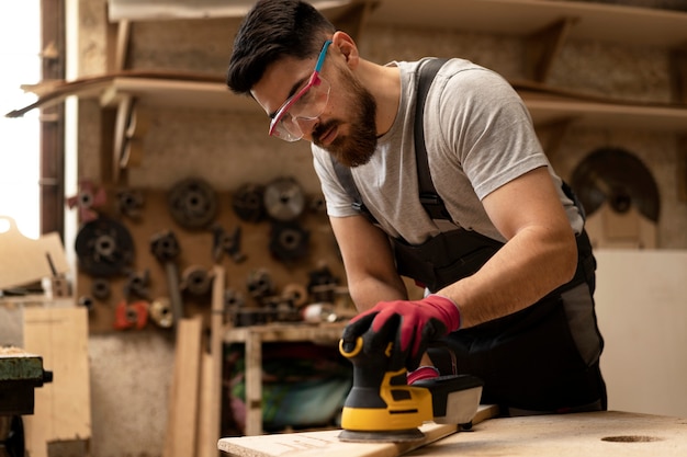 Gratis foto timmerman die mdf-plaat snijdt in werkplaats