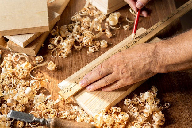 Gratis foto timmerman die met potlood aan een stuk hout werkt