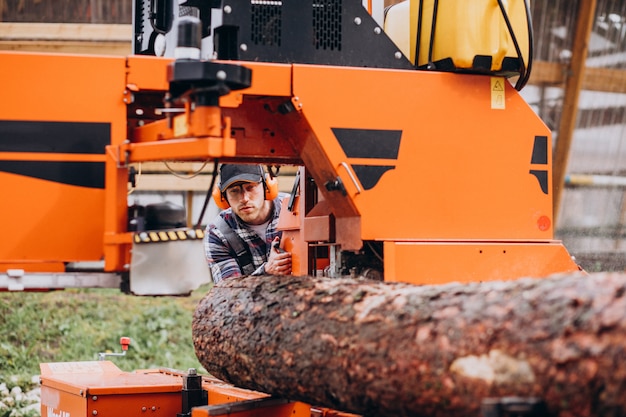 Timmerman werkt op een zagerij op een houtfabriek