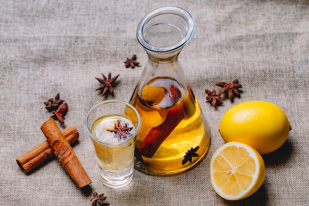 Gratis foto tinctuur met citroenanijs kaneel drinken citroenschil zijaanzicht