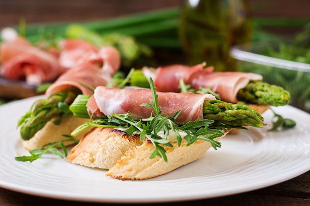 Toast met asperges, rucola en prosciutto.