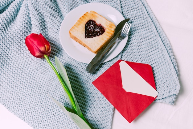 Gratis foto toast met jam in hartvorm met tulp op sjaal