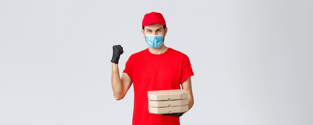 Toepassing voor voedselbezorging online boodschappen contactloos winkelen en covid19-concept Snelle en veilige bezorgkampioenen in de industrie Koerier in rode uniforme vuistpomp bezorgt pizzabestelling