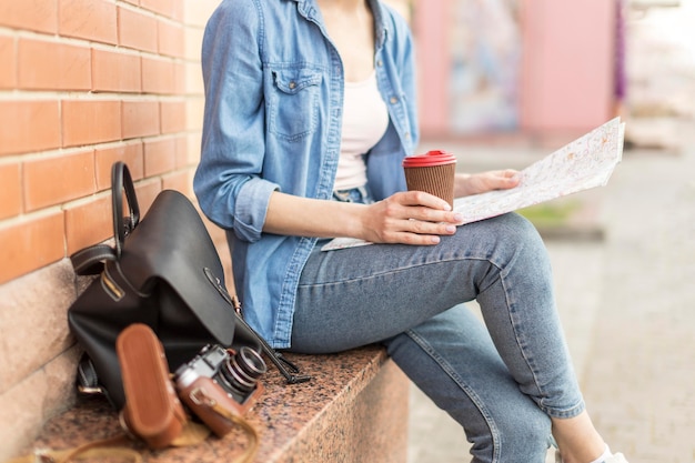 Toerist die van koffie geniet terwijl het controleren van kaart