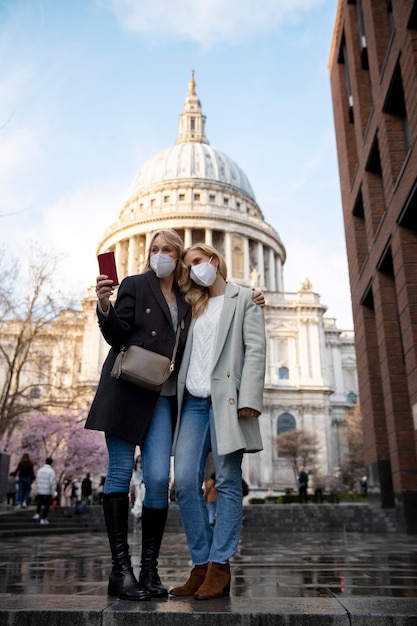 Gratis foto toeristen die de stad bezoeken en een reismasker dragen