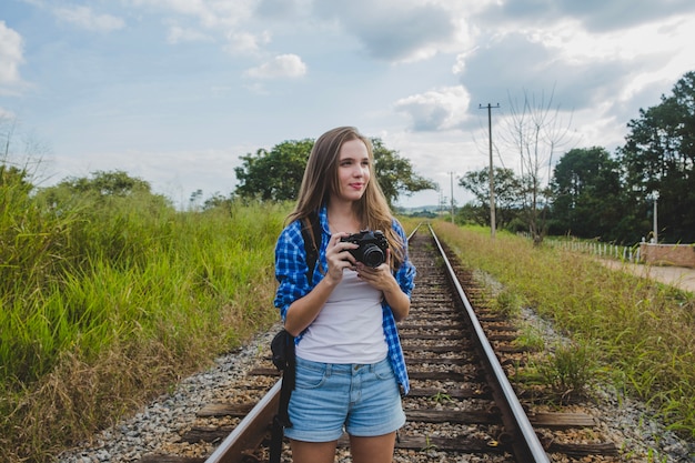 Toeristisch meisje met camera op treinsporen