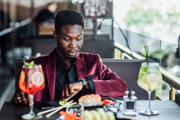 Toeristische man die Aziatisch eten eet, straatlokaal café, kijkend op wacht.