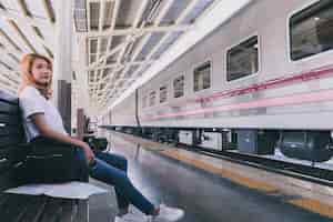 Gratis foto toevallige jonge vrouw op spoorwegpost