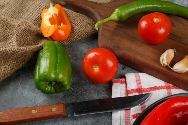 Tomaten en groene paprika's met een mes. bovenaanzicht