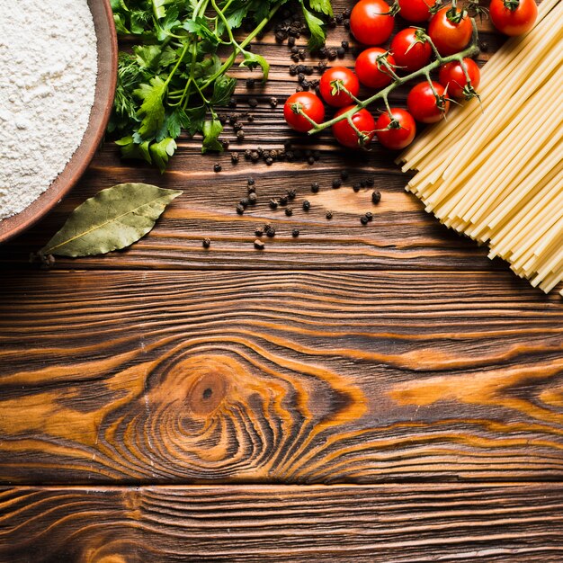 Tomaten en kruiden in de buurt van pasta