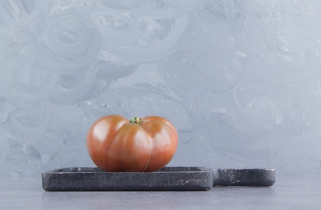 Tomaten in het bord, op het marmeren oppervlak