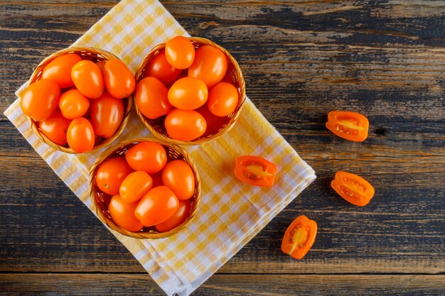 Tomaten in rieten manden plat lag op picknickdoek en houten tafel