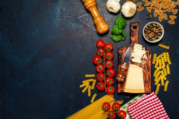 Tomaten met een snijplank met kaas, pasta en kruiden