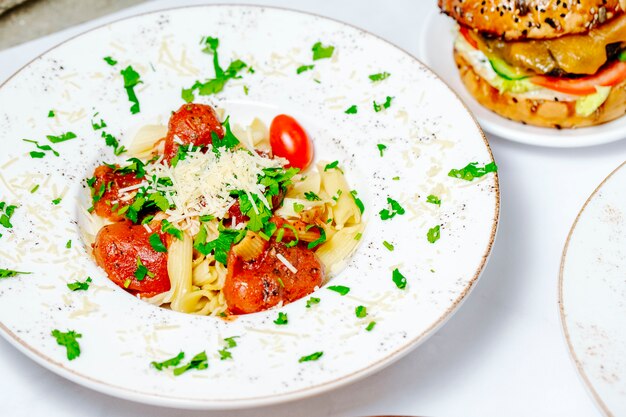 Tomatenpasta gegarneerd met kruiden en kaas