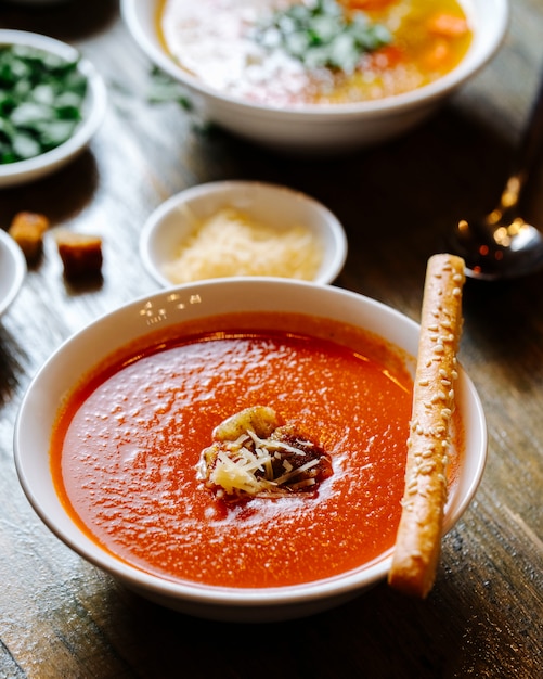 Gratis foto tomatensoep met kaas en cracker bovenop