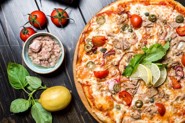 Tonijn pizza tomaat kappertjes kaas ui olijven bovenaanzicht