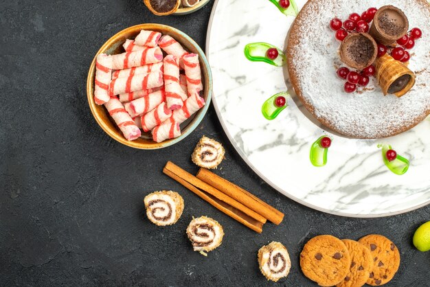 Top close-up bekijken een cake een cake met wafels kaneelstokjes koekjes snoepjes