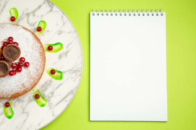 Top close-up bekijken een cake notebook een cake met wafels bessen