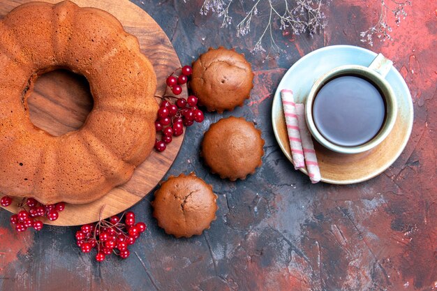 Top close-up cake een kopje thee cake met rode aalbessen op het bord cupcakes boomtakken