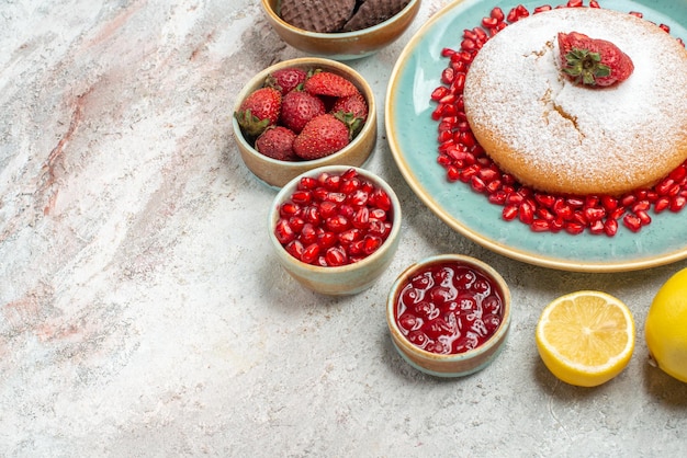Top close-up cake met aardbeien cake met aardbeien zaden van granaatappel koekjes citroen