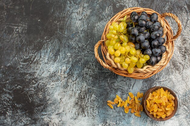 Top close-up weergave fruit gedroogde vruchten in de kom de smakelijke groene en zwarte druiven