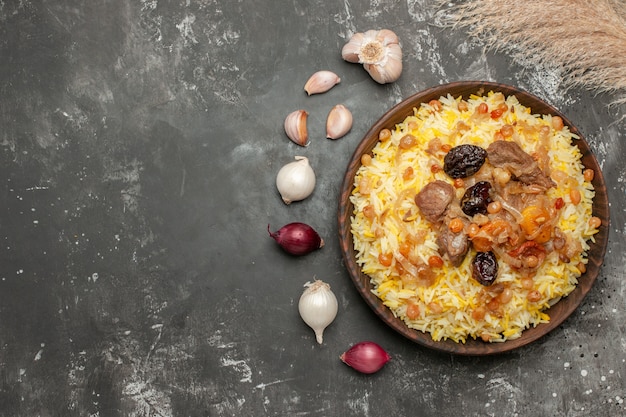 Top close-up weergave pilaf knoflook ui een smakelijke pilaf in de houten kom