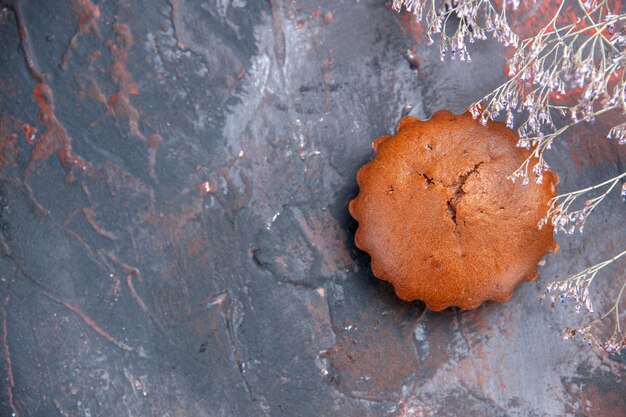 Top close-up weergave smakelijke cupcake boomtakken naast de smakelijke cupcake