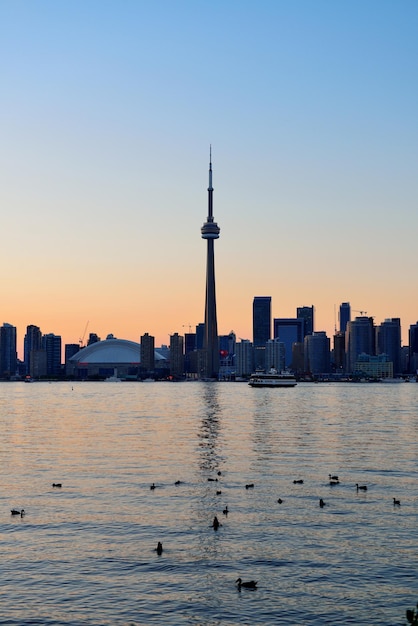 Toronto zonsondergang silhouet in de schemering over meer met stedelijke architectuur.