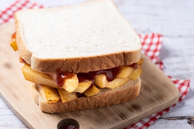 Traditioneel Brits chips butty fritesandwich op een houten tafel