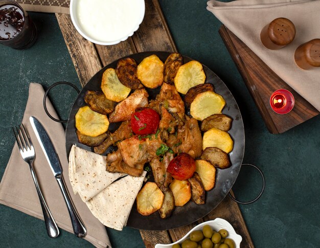 Traditionele Azerbeidzjan schotel geserveerd met yoghurt op een houten bord met bestek