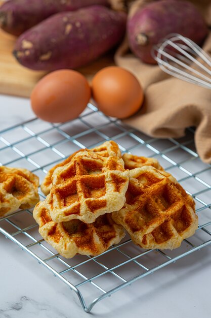 Traditionele Belgische wafels, bloedsinaasappelen en bosbessen dressing en kopje koffie voor zoet ontbijt, samenstelling op lichte achtergrond.