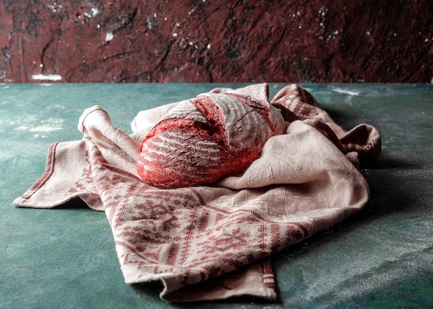 Gratis foto traditionele breadon een bruine rustieke handdoek op stenen keukentafel.