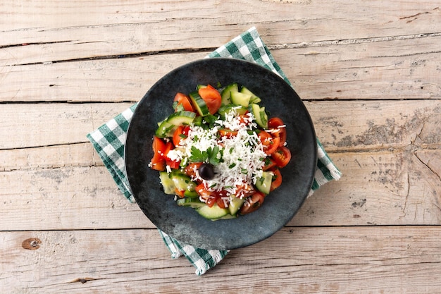 Traditionele Bulgaarse shopska-salade met tomaatkomkommer en Bulgaarse sirene-kaas op houten tafel