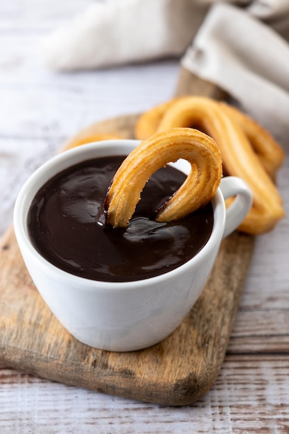 Gratis foto traditionele spaanse churros met warme chocolademelk ontbijt op houten tafel