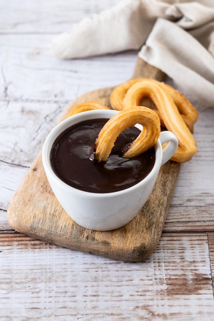 Traditionele Spaanse churros met warme chocolademelk ontbijt op houten tafel